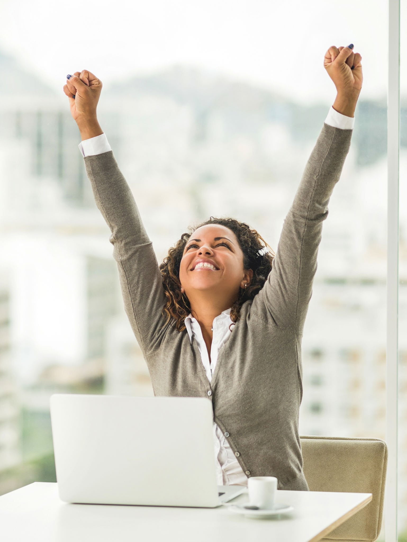 Successful African American businesswoman celebrating her success in the office.
